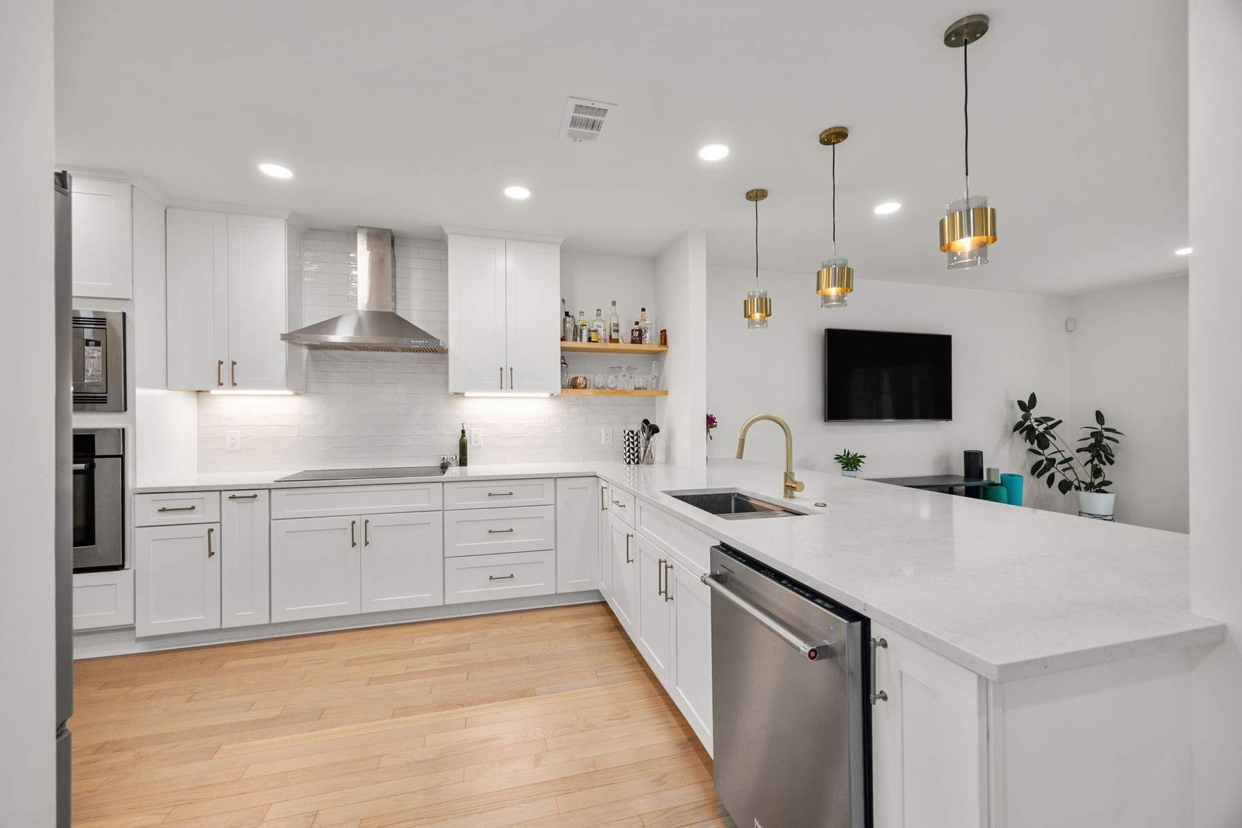 Completed kitchen with white cabinetry, stone counters, island, and stainless appliances