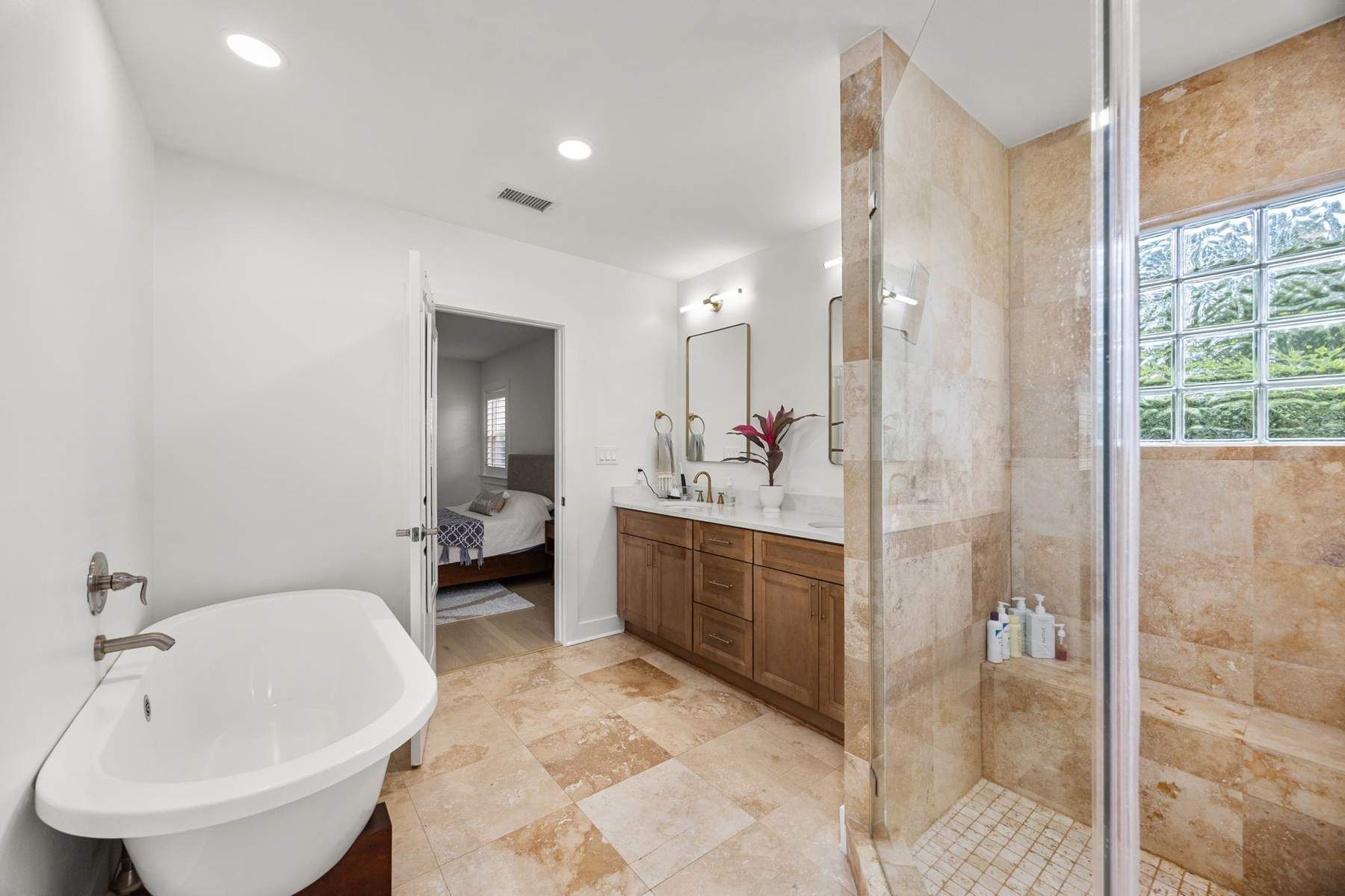 Finished bathroom with a freestanding tub, tiled shower, and wood vanity
