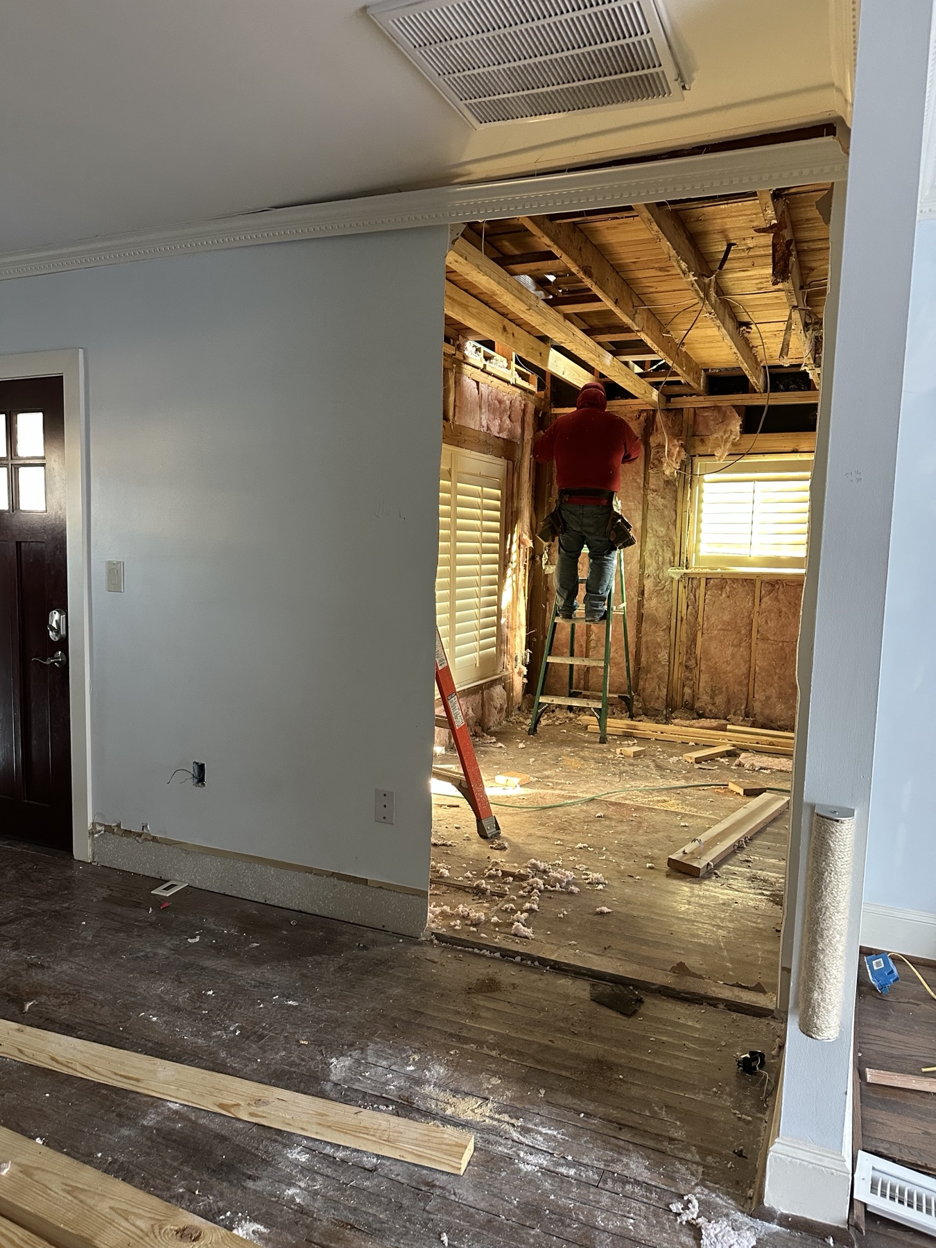 ALZ construction worker completing framing inside the opened bungalow
